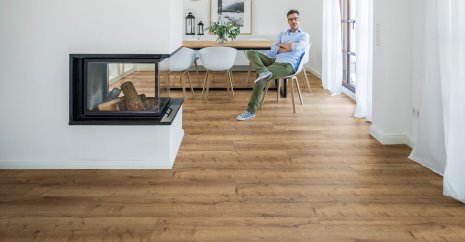 wineo Designboden mit einem Mann im Esszimmer und moderner Einrichtung