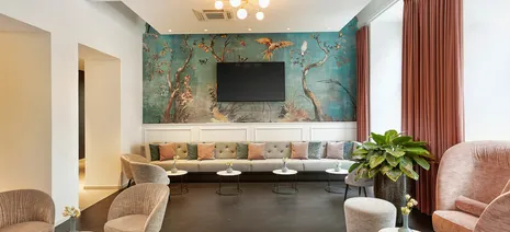 wineo PURLINE Bioboden im Fischgrätmuster in Hotellobby verlegt mit edler Wandtapete, gemütlichen Sesseln und einem großen Sofa im Hyperion Hotel in Salzburg