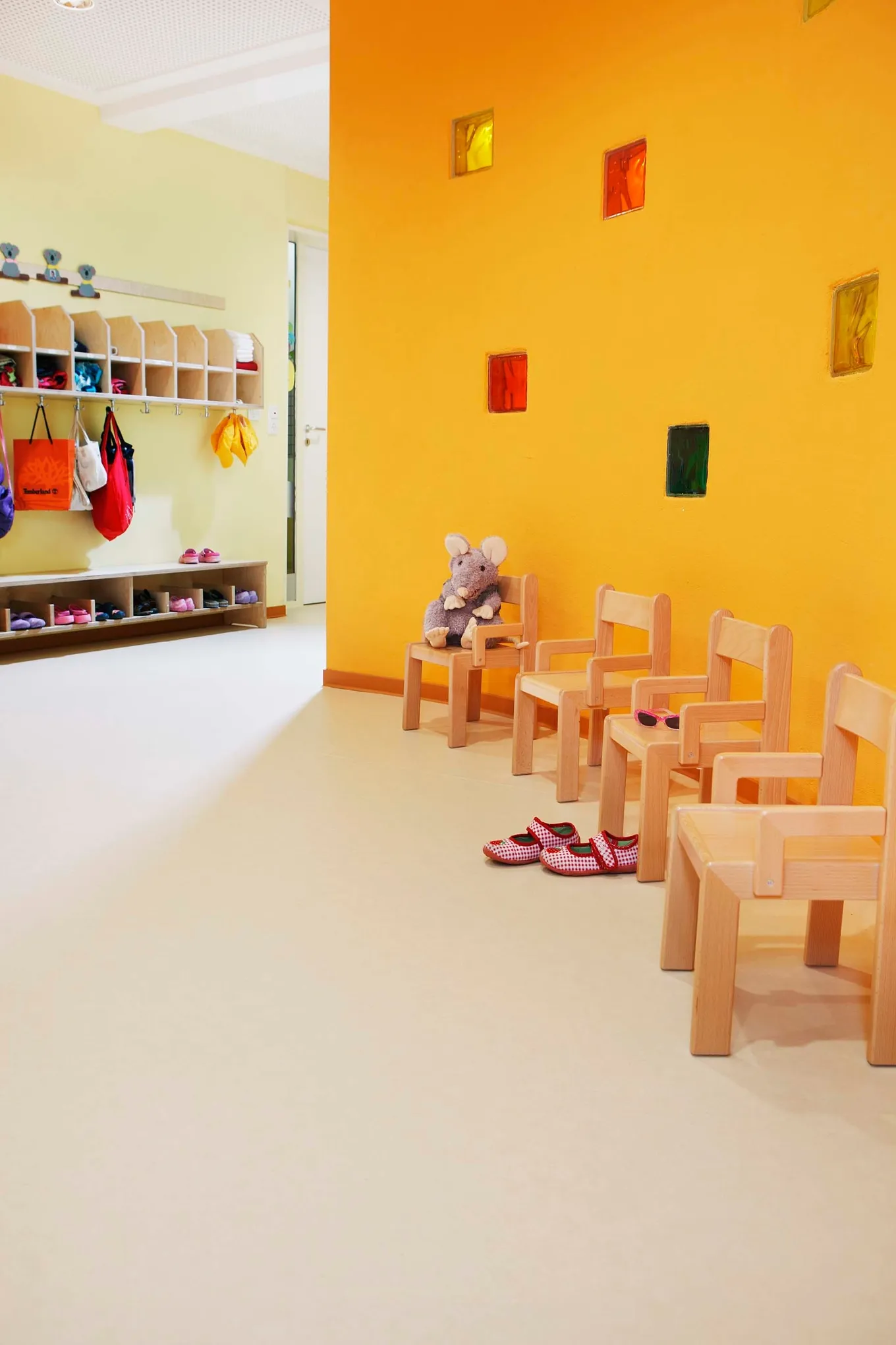 PURLINE Bioboden Sinai Sand in KiTa Kindergarten Eingangsbereich Stühle Rollenware Orange